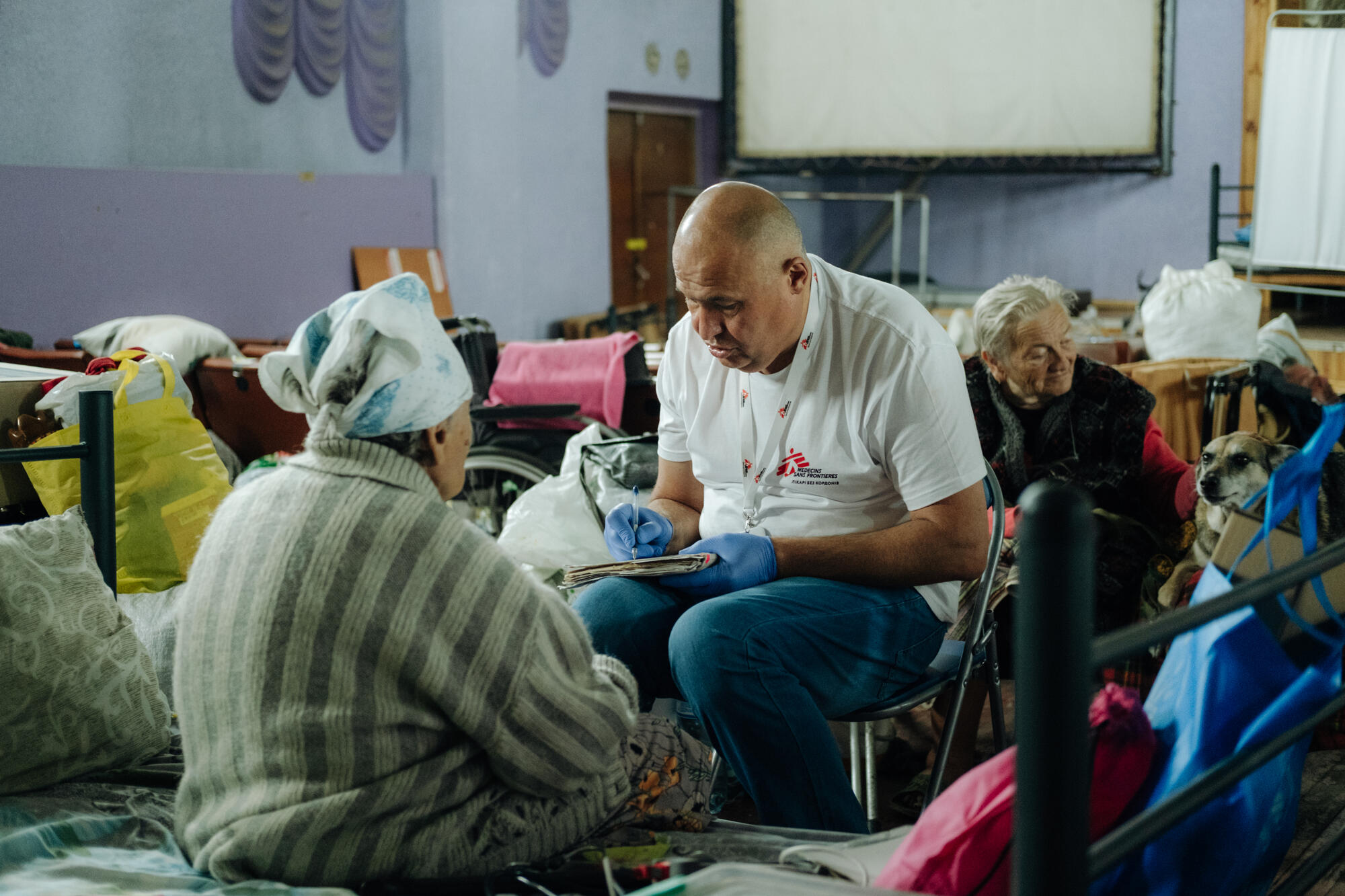 An MSF mobile clinic team examines patients at a transit centre for displaced people in Ukraine.