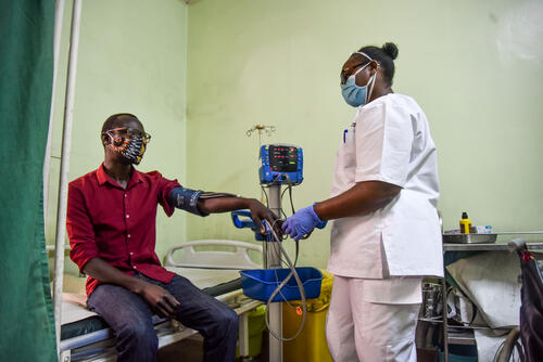 EMT Faith Njeri checks Vitals of a Patient at MSF's trauma room holding area