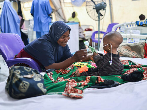 Latifat Abdulkareem playing with her seven-month-old daughter Aisha Abdulkareem who is on admission and is being treated for malnutrition at MSF’s facility Nilefa Kiji, Maiduguri, Borno state, northeast Nigeria. Latifat says that she brought her daughter to the MSF facility after she fainted. Latifat narrates that she felt terrible when her daughter fainted. For days, she could not sleep because she feared that her daughter would not make it. Aisha has been on admission for five days. Latifat said that she has other children at home and is worried about them. Recently, she had to ask that her eldest son be brought to her in the hospital. He said that they were hungry since I was not around. That made me feel sad. Lately, I have been joining the group sessions at the mental health ground. The counsellors are very kind.