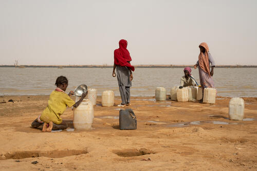 Ouré-Cassoni, Chad - July 23, 2026. Children fill jerrycans with water taken from Lake Karyari, near the refugee camp. In an attempt to get cleaner water, they dig holes in the ground. Water supplied to the camp does not meet residents' needs. Families send children to fetch water from the lake, where the shoreline is contaminated with animal feces. However, the water drawn from the holes is also contaminated.  CREDIT: Flurina Rothenberger for Médecins Sans Frontières.