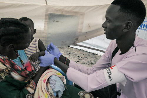 MSF Nurse Gatwech Tuoch immunizes a child against measles