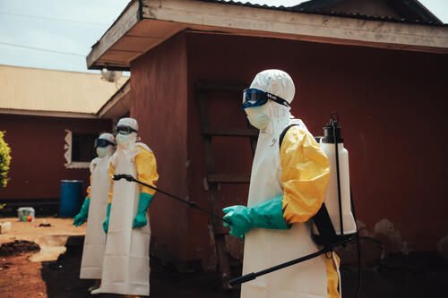 Une fois toute la maison décontaminée, l'équipe de décontamination se rassemble en attendant de pouvoir enlever la combinaison.

Once the whole house has been decontaminated, the decontamination team gathers together whilst waiting to take off their protective suits.