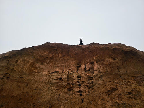 7 A child overlooks the camps from an eroded hill top