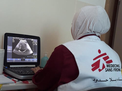 An MSF staff inspects the echography of a patient during a mobile clinic in Khallet Al Mai, Hebron, West Bank. Occupied Palestinian Territory.