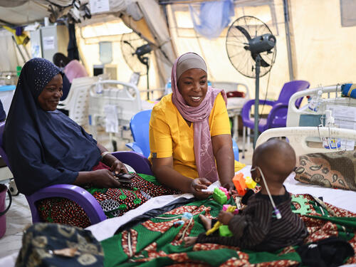 MSF counsellor educator, Maryam Alimu having a play therapy session with Latifat Abdulkareem’s seven-month-old daughter Aisha Abdulkareem, who is on admission and is being treated for malnutrition at MSF’s facility Nilefa Kiji, Maiduguri, Borno state, northeast Nigeria. These play sessions are part of activities organised by the MSF mental health team to help both the children suffering from malnutrition and their caregivers. Latifat says that she brought her daughter to the MSF facility after she fainted. Latifat narrates that she felt terrible when her daughter fainted. For days, she could not sleep because she feared that her daughter would not make it. Aisha has been on admission for five days. Latifat said that she has other children at home and is worried about them. Recently, she had to ask that her eldest son be brought to her in the hospital. He said that they were hungry since I was not around. That made me feel sad. Lately, I have been joining the group sessions at the mental health ground. The counsellors are very kind.