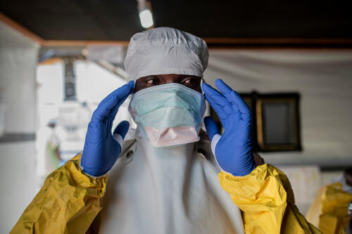 Medical and hygienist staff get dressed with the PPE to get into the high risk zone of the Ebola Transit Center in Bunia