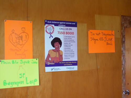 Inside the Family Support Centre, in Minj, Jiwaka Province, Papua New Guinea, posters remind visitors that violence is a crime and help is available.