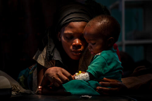 A mother with a child suffering from malaria wait at the emergency service at Rutshuru General Referral Hospital.