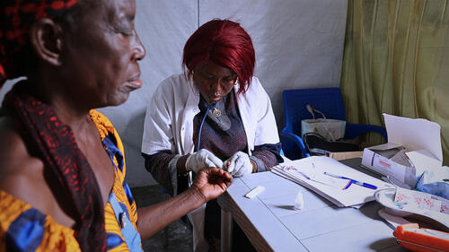 Une infirmière de clinique mobile de MSF effectue un test de diagnostique rapide sur une bénéficiaire dans la zone de santé de Limete, à Kinshasa