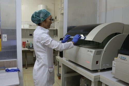 Lab technician checks the samples in biochemical blood analyser