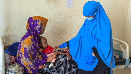 prepares F-75 therapeutic milk in the feeding preparation room of the inpatient malnutrition ward at Mudug Regional Hospital. F-75 is used in the first phase of treatment, while a severely malnourished child’s body cannot yet tolerate the higher-energy formula given during recovery.
