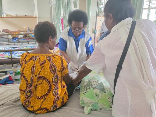 Sister Abel, nurse manager of the palliative care ward at ANGAU Memorial Provincial Hospital, sees a patient with the assistance of a newly recruited nurse.
