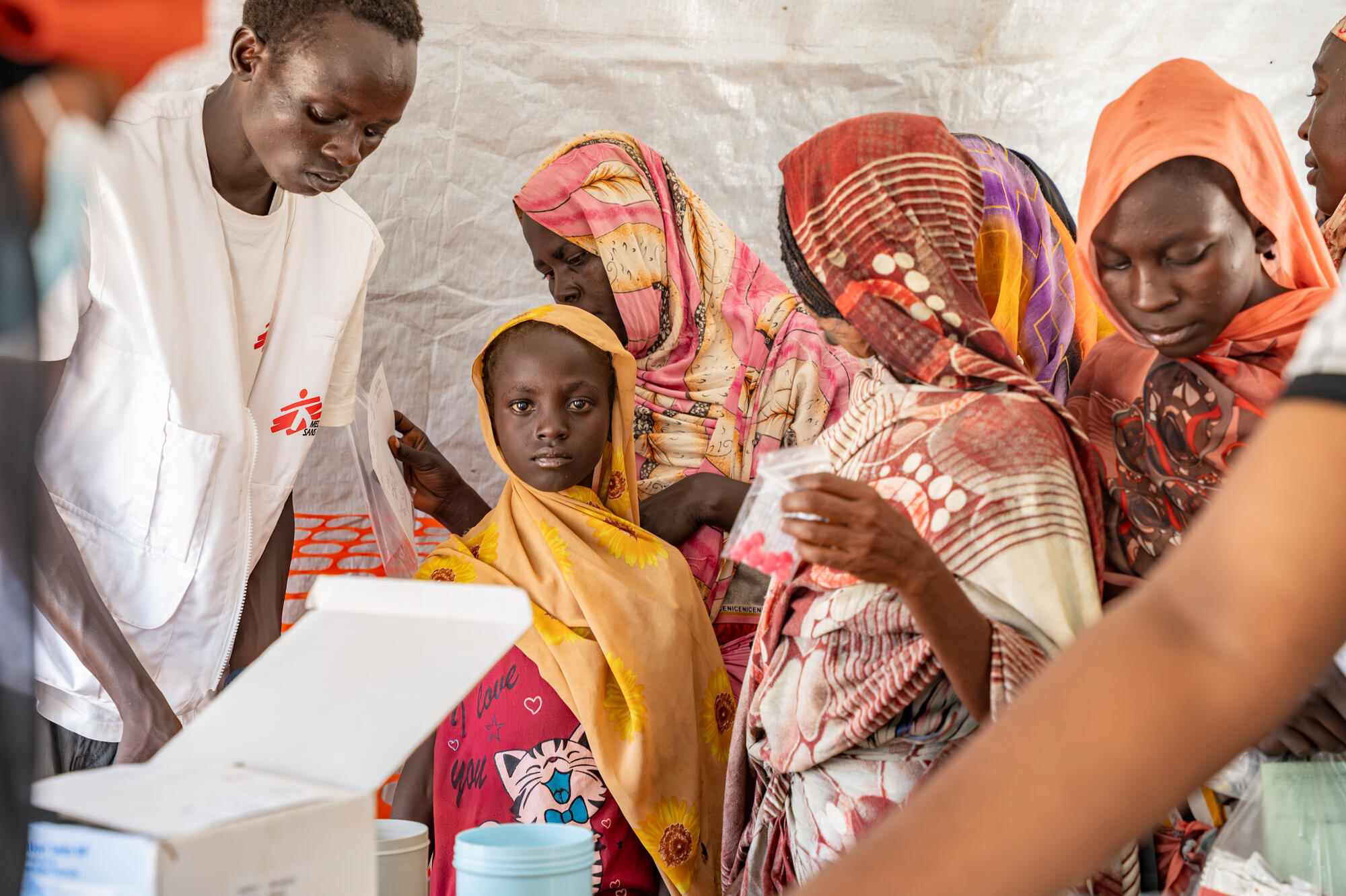 A woman accompanies her mother to an MSF mobile clinic for people displaced from Sudan in Renk County, South Sudan.