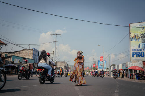 Une femme traverse la route au niveau de l’Hôpital Général de Référence (HGR) dans le centre-ville de Goma. 

A woman crosses the road near the General Reference Hospital (HGR) in downtown Goma.