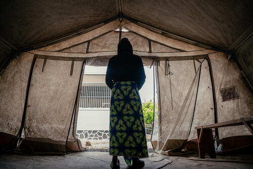 
Joëlle (prénom modifié). Portrait d'une mineure de 17 ans, debout dans une tente au centre de santé de CCLK à Goma. Orpheline, elle vit seule avec ses trois petits frères depuis la mort de leurs parents. Après un entretien avec le superviseur MSF en charge de la protection, elle est venue recevoir des soins dans le cadre de sa prise en charge. 

Joëlle (first name changed). A 17-year-old orphan stands in a tent at the CCLK Health Centre in Goma. Since losing her parents, she has cared for her three younger brothers on her own. After meeting with the MSF protection supervisor, she has come to receive support and medical care.