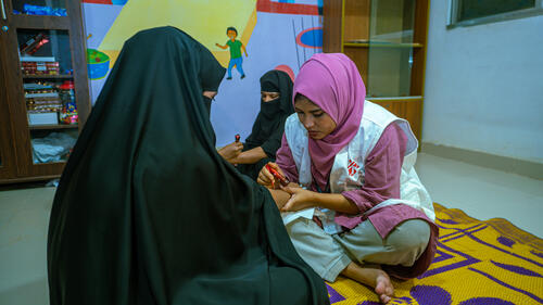 At the MSF mental health department in Kutupalong Hospital, social worker Fatema Jinnat Laboni and counselor educator Rozina Akter facilitate a psychosocial support session. Using activities like applying henna, the team fosters an informal environment that helps them build trust, listen to patient experiences, and better understand their psychosocial needs.