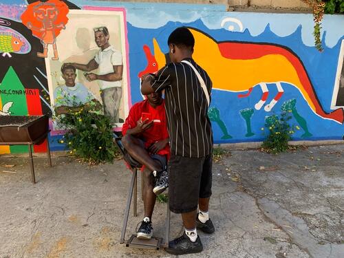 Two unaccompanied minors, cutting their hair and having some respite at the day center called Le GR1, located in Marseille.