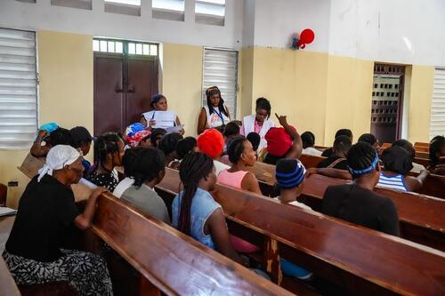 Patients are waiting their turn in a waiting room set up inside a church.