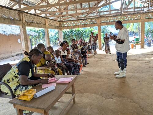 While waiting for their children to be vaccinated, Jadida, an MSF health promoter in Budjala speaks with mothers to explain the importance of the measles vaccine. This vaccination is essential for the community, as it protects each child while strengthening herd immunity and helping to curb the spread of a highly contagious virus.