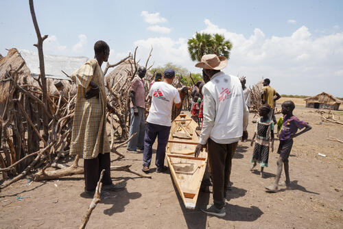 Community members looking at a canoe donated by MSF