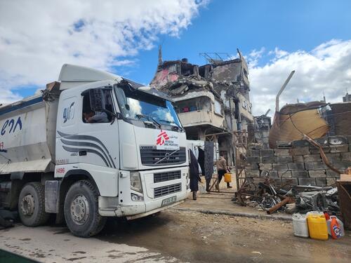 Water distribution point along the costal road. The truck distributes 15,000 liters of water per trip, doing 2-3 trips a day. 15,000 liters gives about 2,500 people emergency levels of 6 liters of drinking water per person.