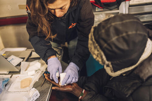 MSF nurse cleaning a wound of a Sudanese refugee in Calais