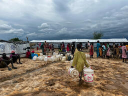 People in line at a water point in Transit Centre in Renk