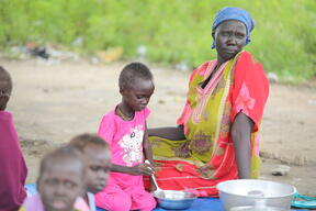 A mother prepares meals for her children at Renk Civil Hospital