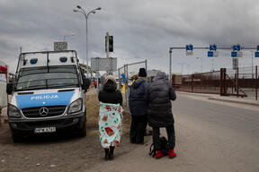 People wait to welcome refugees