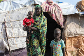 A mother with her children in front of their shelter