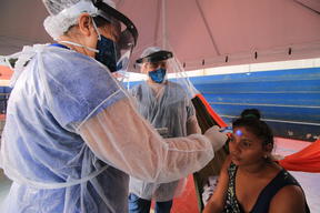 Health team takes the temperature of an indigenous Warao woman in an isolation and observation center for people with mild cases of COVID-19