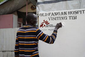 A man paints the new MSF hospital sign