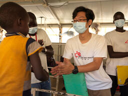Dr Siu Chung Ha engages with a patient in the children's ward at MSF hospital