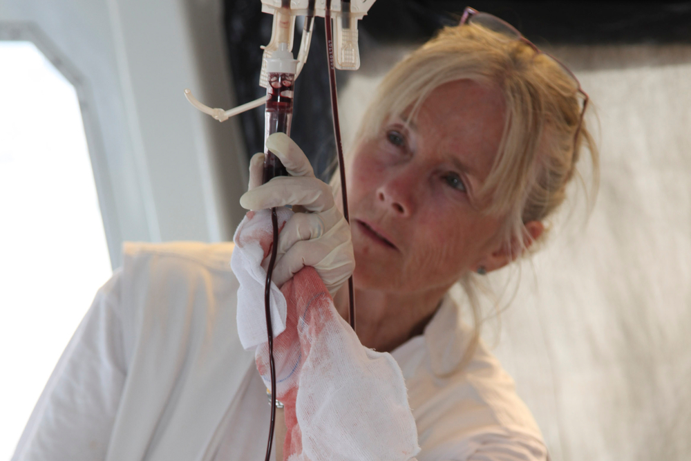 Alison Criado-Perez adjusts a blood transfusion as MSF evacuates 99 people, including 64 war-wounded, by boat from Misrata, Libya, to Zarzis, Tunisia, in April 2011. 