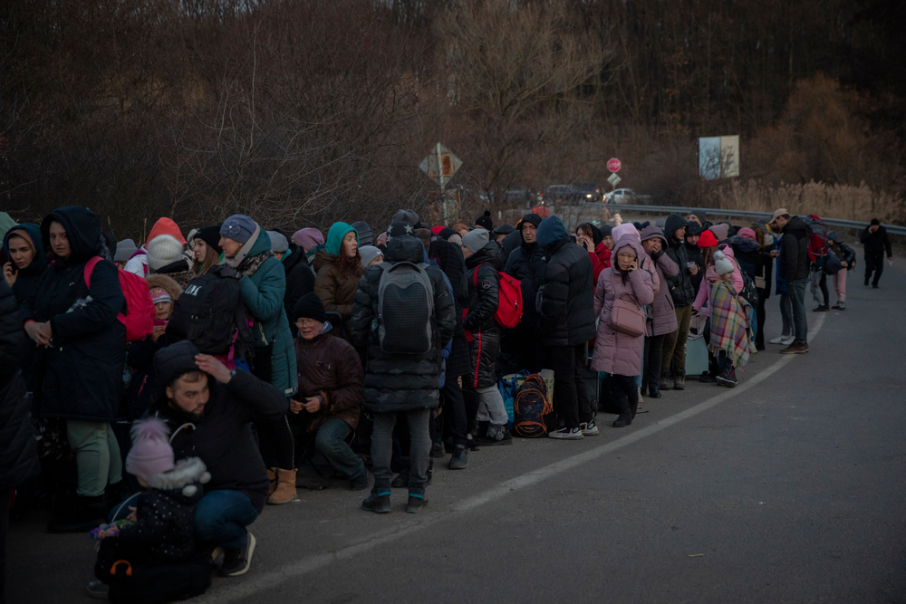 Hundreds of people wait in line to cross the border on foot into Slovakia from the city of Uzhhorod in Ukraine's Transcarpathia region, March 6, 2022. 