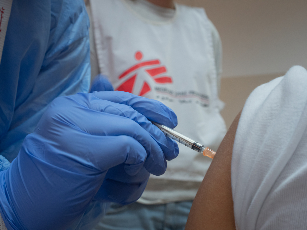 MSF worker vaccinates a person
