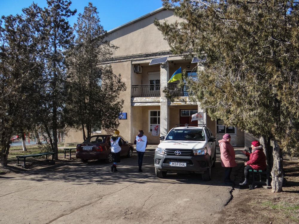MSF staff members and patients outside the mobile clinic in Pavlopil. February, 2019.