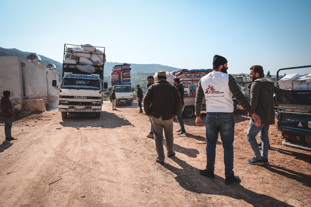 MSF staff in front of truck with relief items