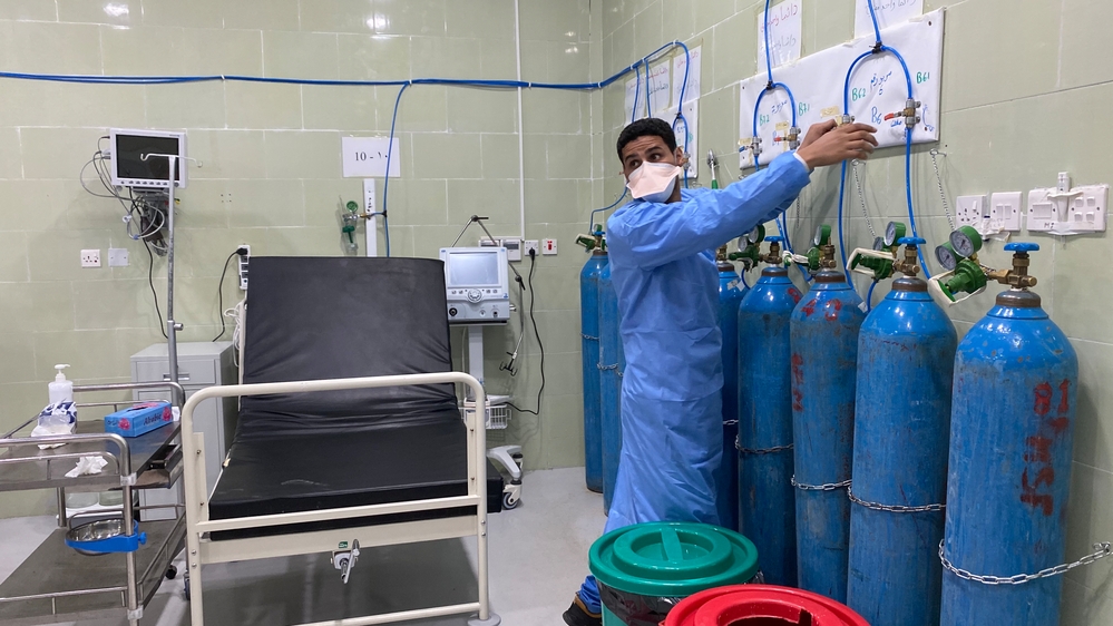 MSF health worker is adjusting an oxygen cylinder 