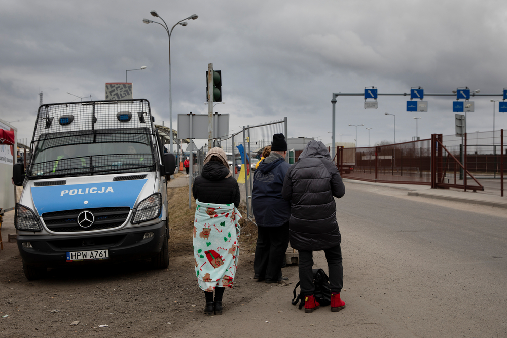 People wait to welcome refugees or family members fleeing Ukraine, at the border in Dolhobyczow, Poland, on March 5, 2022.