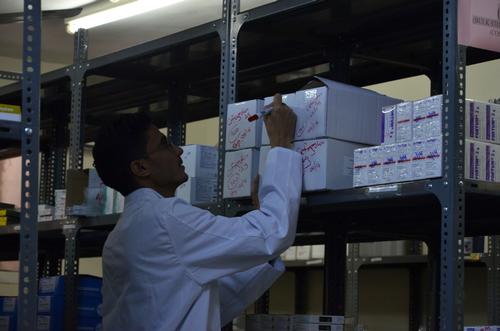 MSF pharmacy store keeper in Yemen checking stocks.